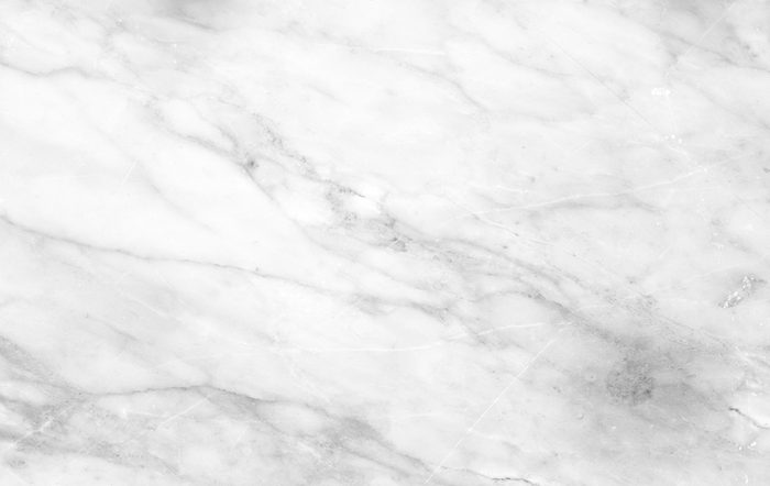 White marble surface; displaying soft gray veins; smooth, polished appearance.