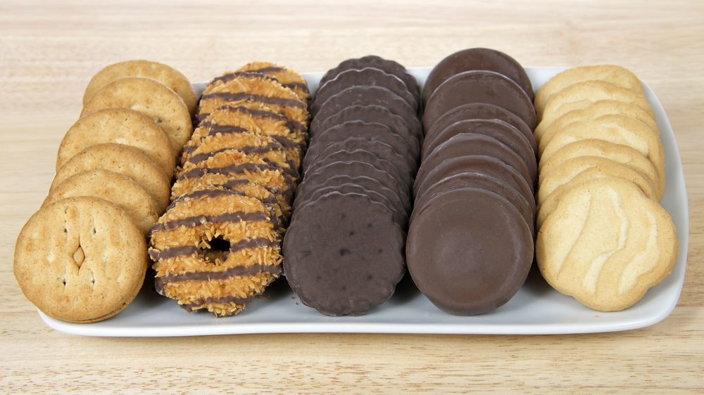 Cookies arranged neatly on a white rectangular platter with a wooden surface background.
