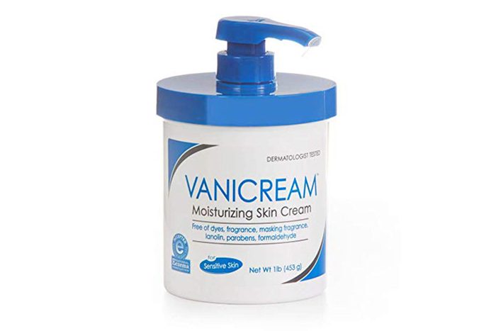 Cream container with a pump sits on a white surface; labeled 