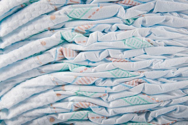 Diapers are stacked neatly, showcasing folded white and pastel-patterned surfaces in close-up view.