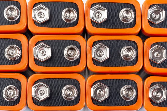 Rectangular 9-volt batteries arranged closely, displaying metal terminals. Orange borders frame each battery against a plain white background.