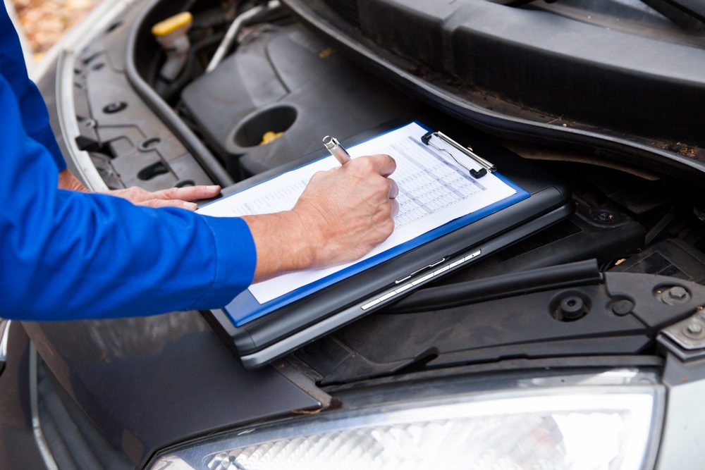 Close-up Of A Mature Mechanic Maintaining Car Records
