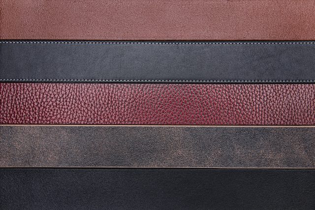 Leather strips arranged horizontally; each varies in texture and color, including brown, black, and maroon, against a plain background.