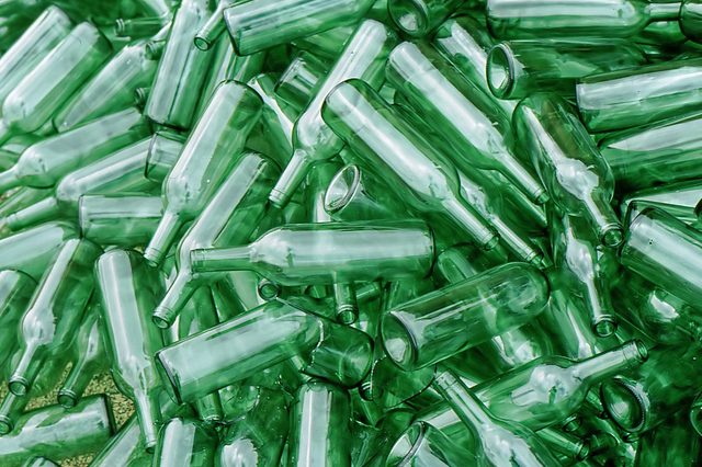 Glass bottles lay scattered, overlapping each other, creating a dense, jumbled pile.