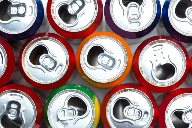 Aluminum cans form a colorful, tightly packed grid, viewed from above, displaying various shades of red, orange, green, and purple.