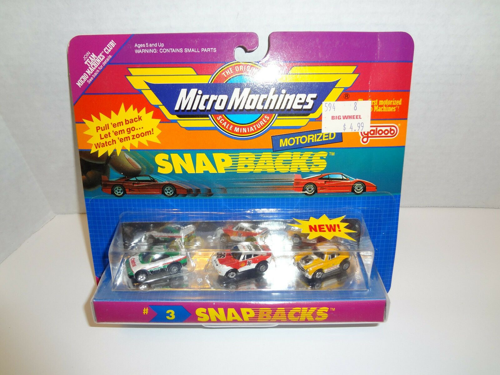 Toy cars are packaged under colorful branded cardboard, with text highlighting "Snap Backs" and price tag reading "$4.99 Big Wheel."