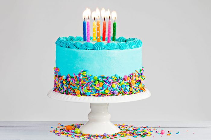 Blue Birthday with lit candles over light grey.