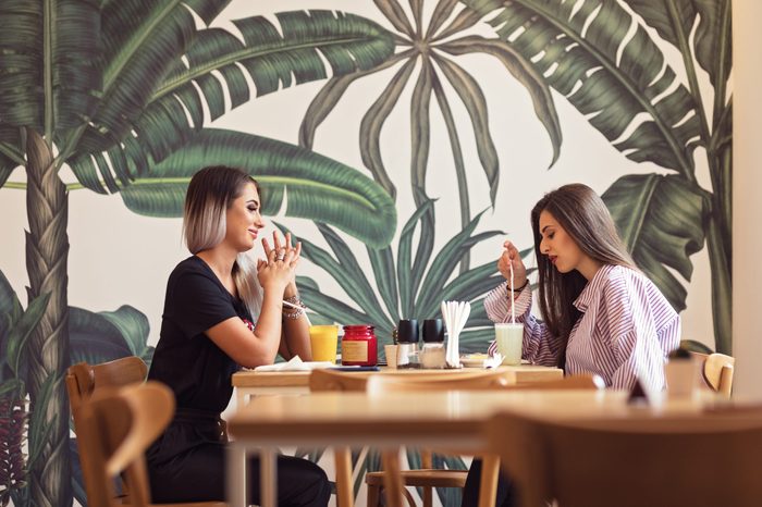 girlfriends out in town for drinks, lunch, spending quality time, eating tasty food and drinking together. Girls waiting for friend to make important announcement getting excited to hear new secret