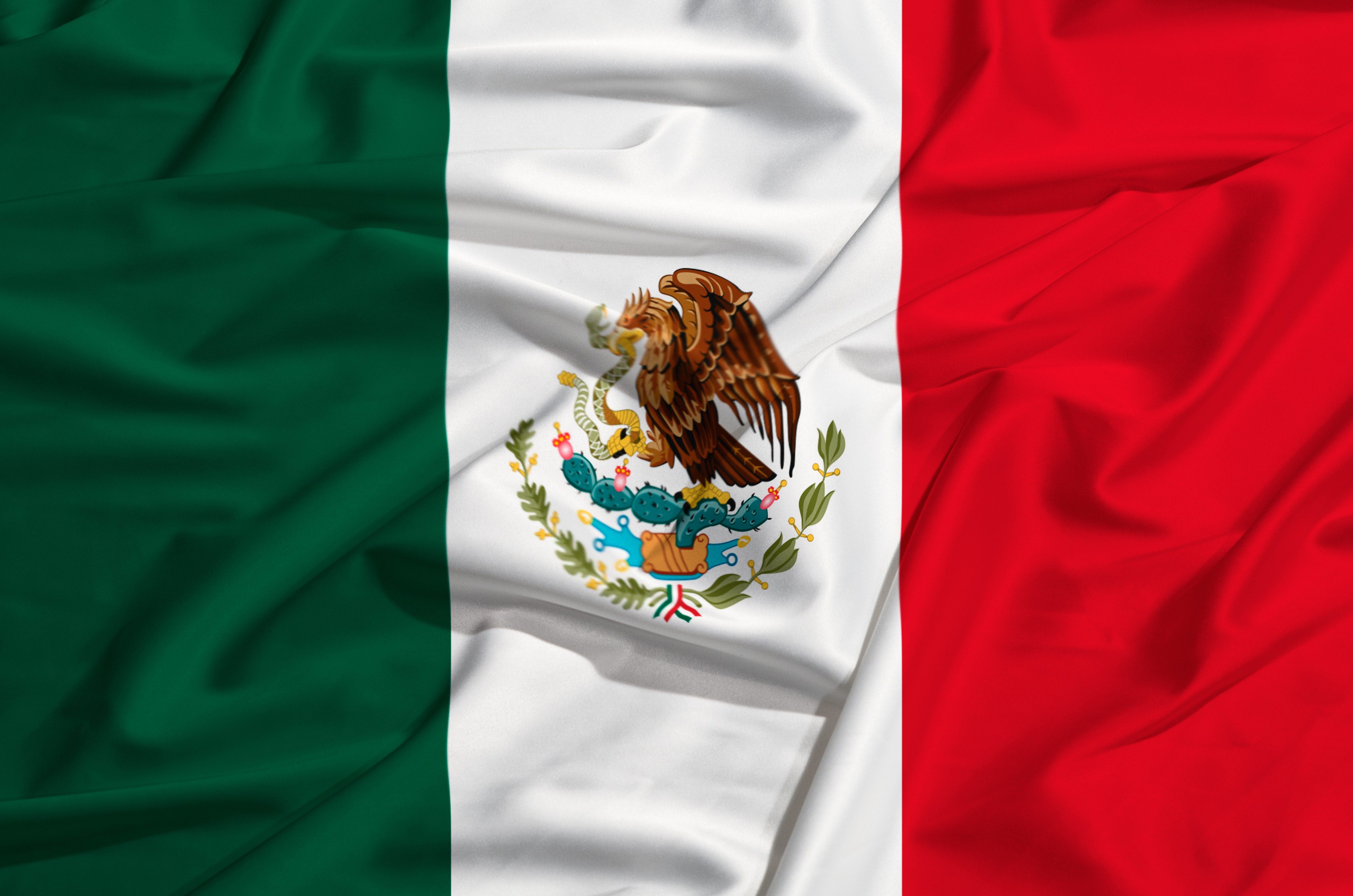 The Mexican flag displays vertical green, white, red stripes with an eagle devouring a snake on a cactus in the center of the white stripe.