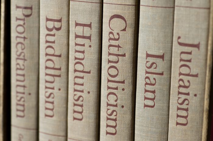 Book spines listing major world religions - Judaism, Islam, Catholicism, Hinduism, Buddhism and Protestantism. The focus is on the word, Catholicism.