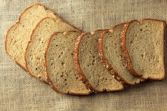 Wholegrain sliced organic bread composed of oats and flax seeds on wooden table. Healthy Diet.Top view