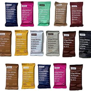 A variety of RXBAR protein bar packets arranged in rows, with text listing ingredients like egg whites, almonds, and dates.