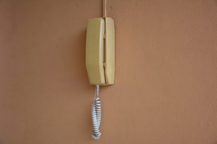 Old office phone on the orange wall