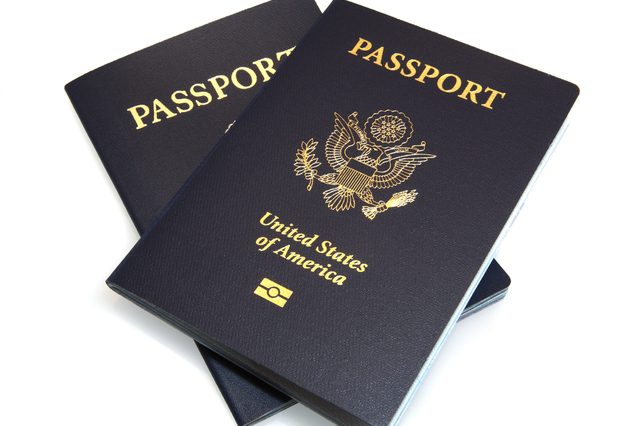 Two U.S. passports, one atop the other, display gold text and emblem on a white background.