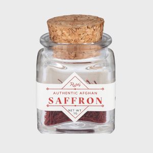 Jar holds saffron strands, sealed with a cork, labeled 