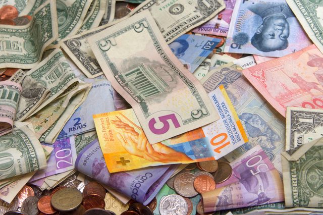 Various currencies scattered, including US dollars, Brazilian reais, Chinese yuan, and other international bills and coins, resting on a flat surface.