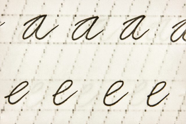 Cursive letters "a" and "e" repeat on lined paper, showcasing handwriting practice exercises.