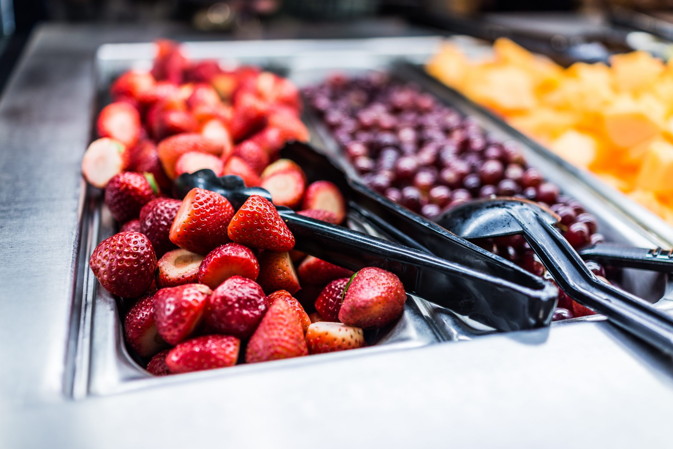 Fruit salad bar with whole strawberries and grapes