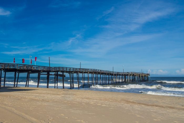 Old wood fishing pier at the sandy beach