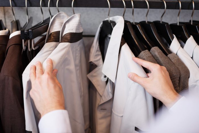 Business shopping, close-up of man choosing shirt at showcase in clothing mall or fashion boutique, wardrobe, point of view shot