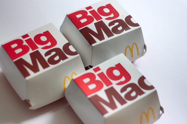 Three Big Mac boxes rest on a white surface, featuring bold red and brown text with a yellow McDonald's logo.