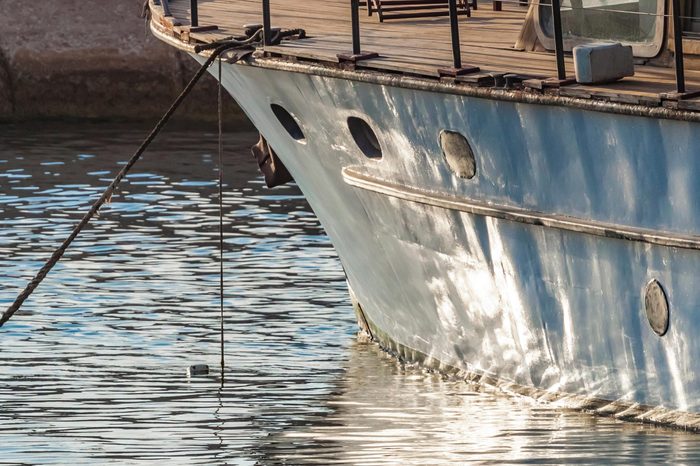 Closeup of bow of old wooden boat anchored