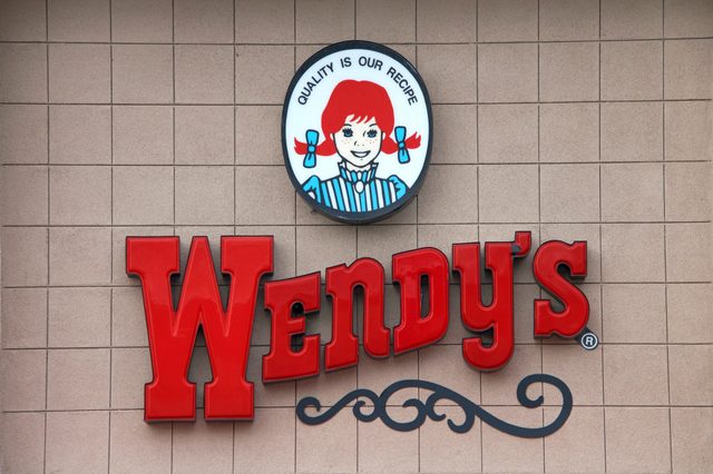 Sign features red "Wendy's" text and circular logo of a girl with red hair, surrounded by beige tiled wall. Text: "QUALITY IS OUR RECIPE."