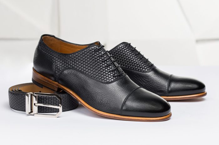Men's leather shoes and belt on a white background
