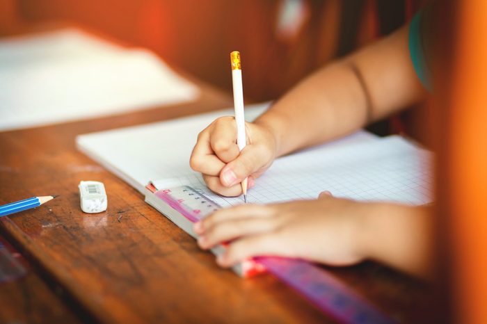 Children's hands are doing their homework.
