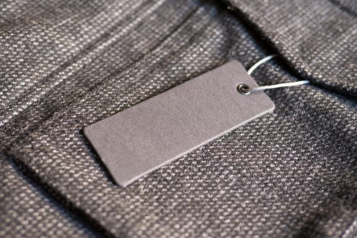 Blank label price tag mockup on brown coat.