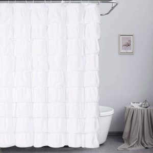 White ruffled shower curtain hanging, concealing a bathtub; beside it, a small table draped with cloth, topped with decor and a magazine.