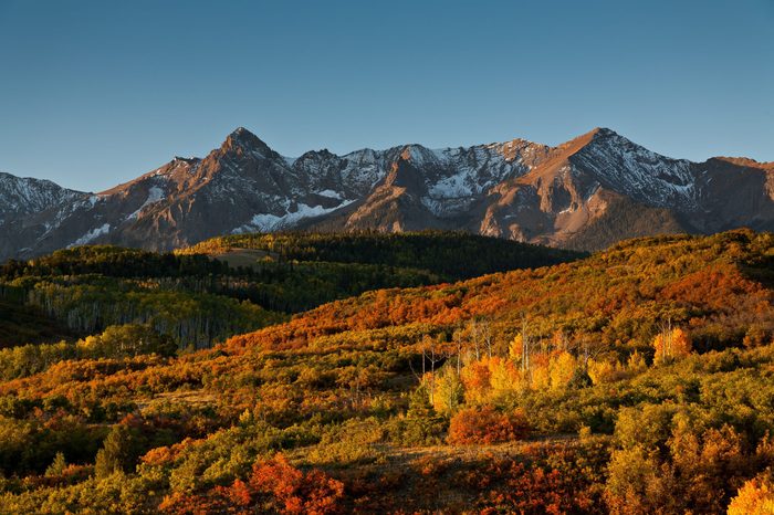 The rising sun illuminates Sneffles Range at Dallas Divide in Colorado's San Juan Mountains