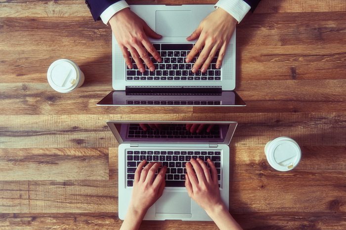 man and woman working on their computers. the view from the top. two laptops, two persons.