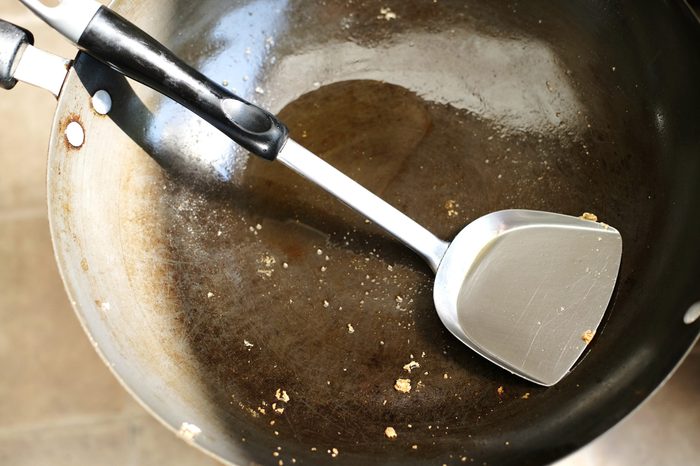 Dirty pan with turner and oil in iron pan after finished cooking food in Thailand