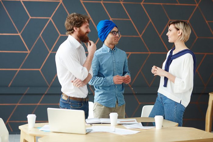 Intercultural men interviewing young female in studio