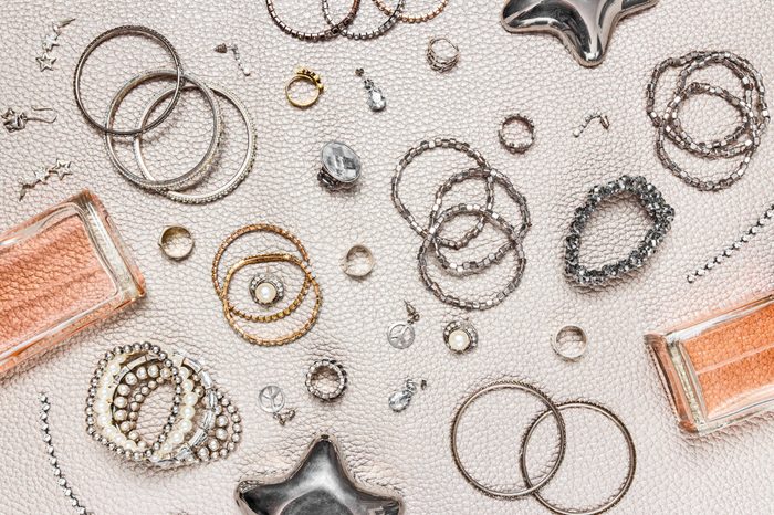 Woman's jewelry and perfume. Flat lay composition. Necklaces, earrings, rings, perfume bottles.