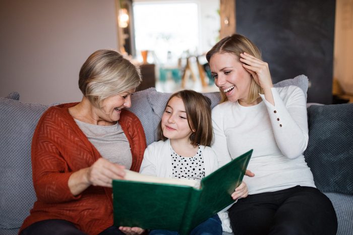A small girl with mother and grandmother at home.