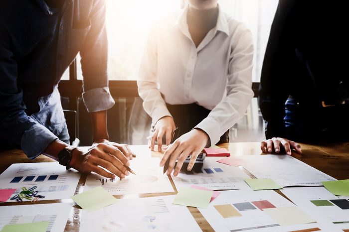 Businessman holding pens and holding graph paper are meeting to plan sales to meet targets set in next year.