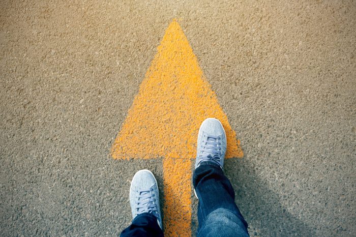 Feet and arrows on road.
