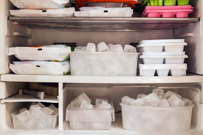 Freezer full of ice cubes and frozen food