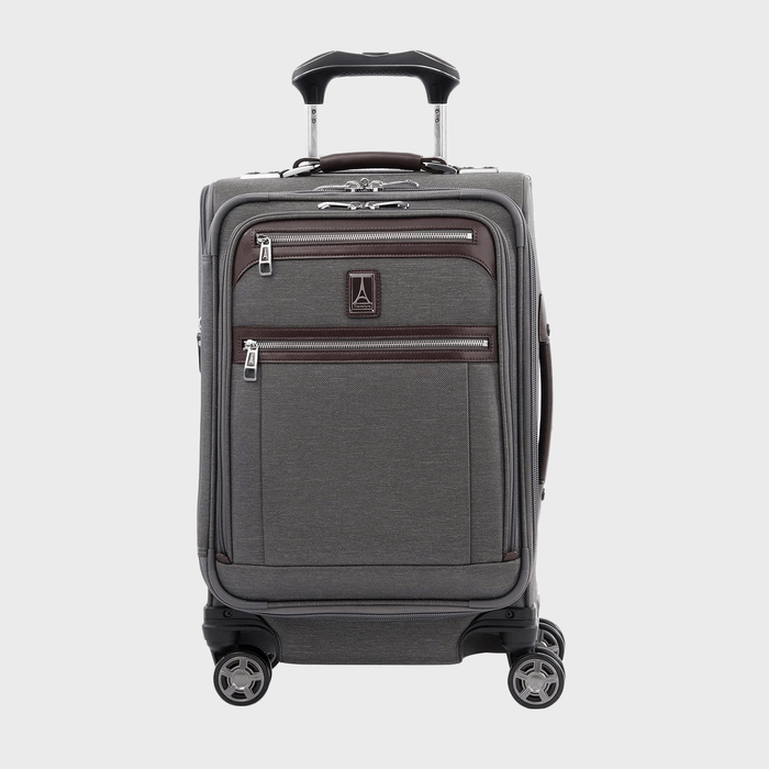 A gray suitcase stands upright with four wheels, featuring two front zippered compartments, a telescopic handle, and a logo. Set against a plain background.