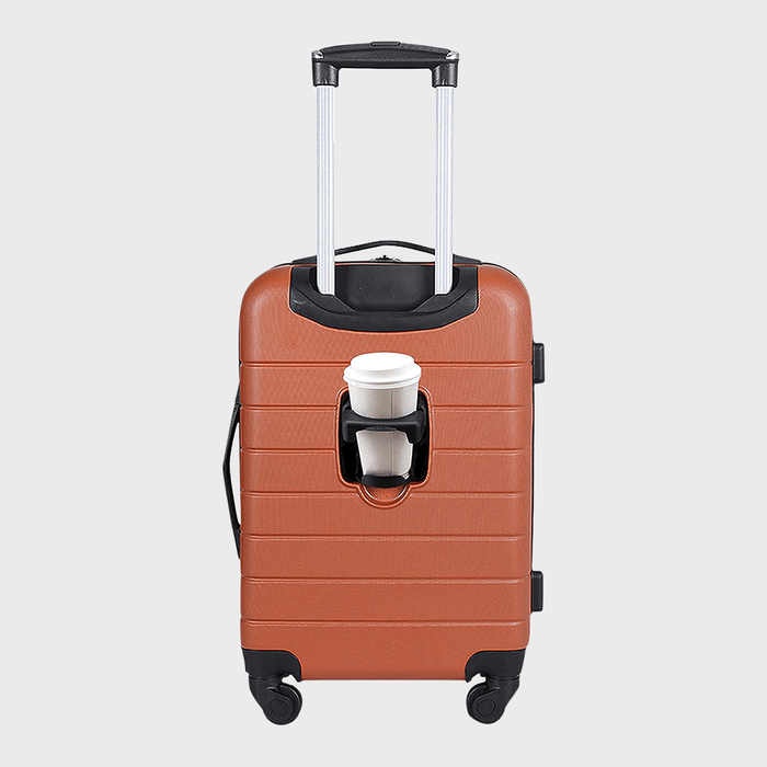 Brown suitcase on four wheels holds a white coffee cup in a built-in holder, set against a plain gray background.