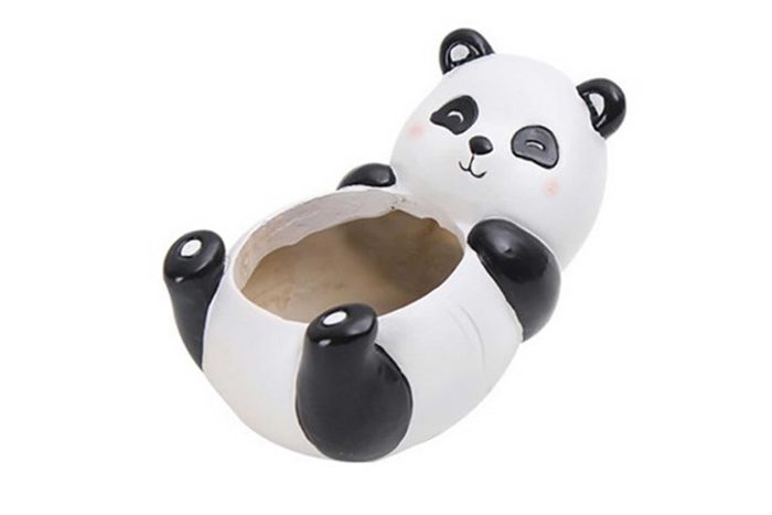 Ceramic panda-shaped container lying on its back, featuring an open cavity. The background is white and plain.