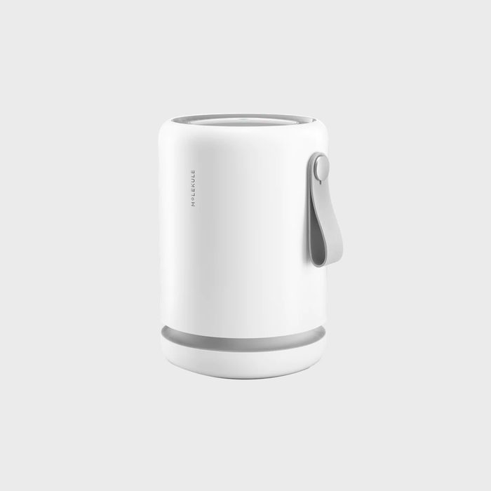 Cylinder-shaped air purifier stands inactive, featuring a gray handle; set against a plain gray background. The text reads 