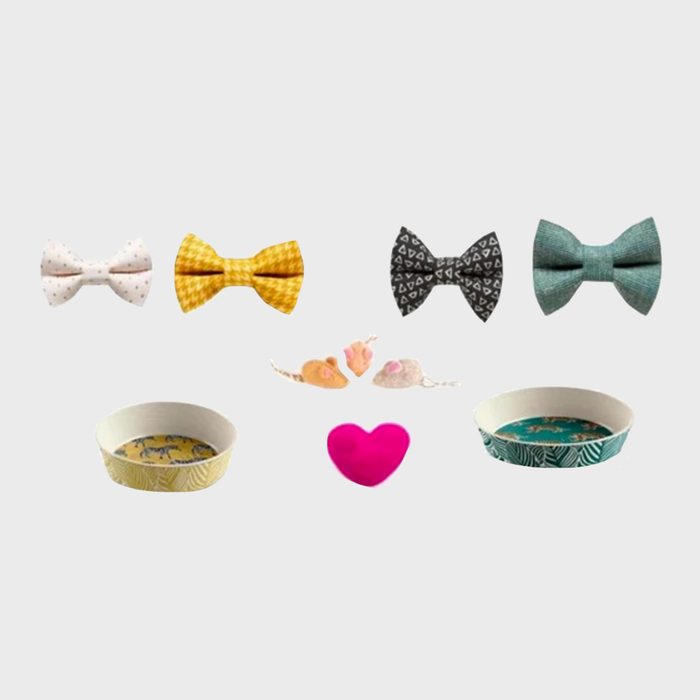 Four bow ties and two toy mice arranged above two pet bowls; a pink heart lies centered beneath them on a plain background.