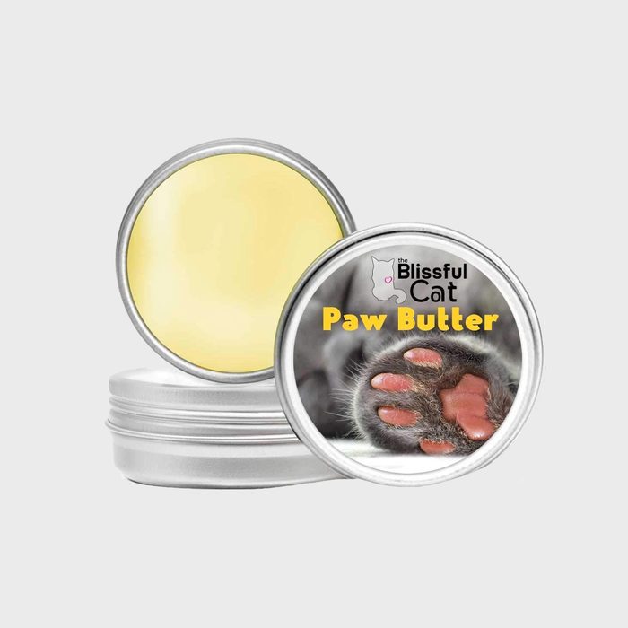 Tin container displays paw butter, lid featuring cat paw imagery. Branding reads 