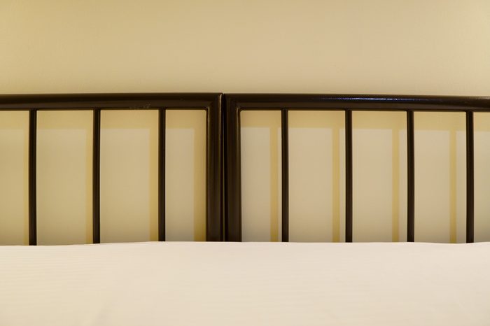 metal bed in a hotel room without pillows