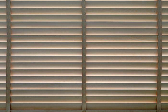 Wood blinds or curtain by the window.