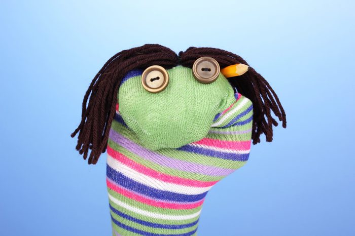Cute sock puppet on blue background