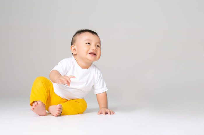 funny baby boy sitting on white background 